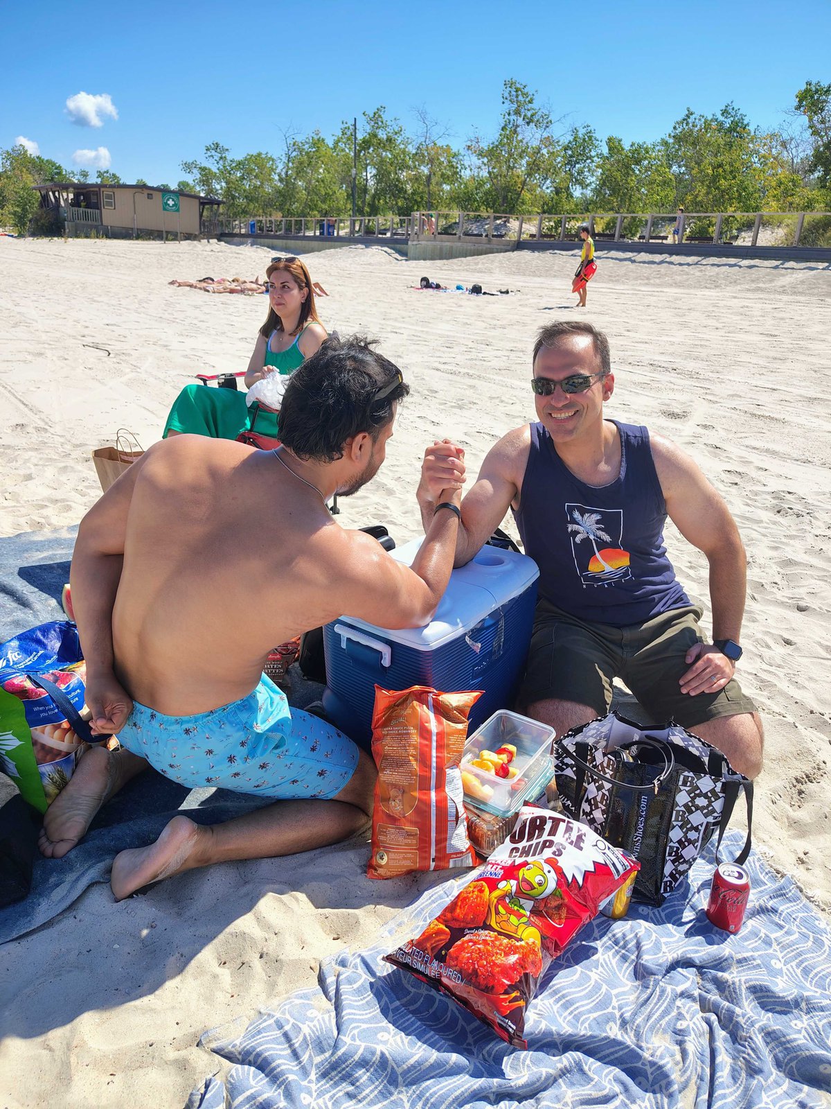 Arm wrestling match on a cooler at the beach