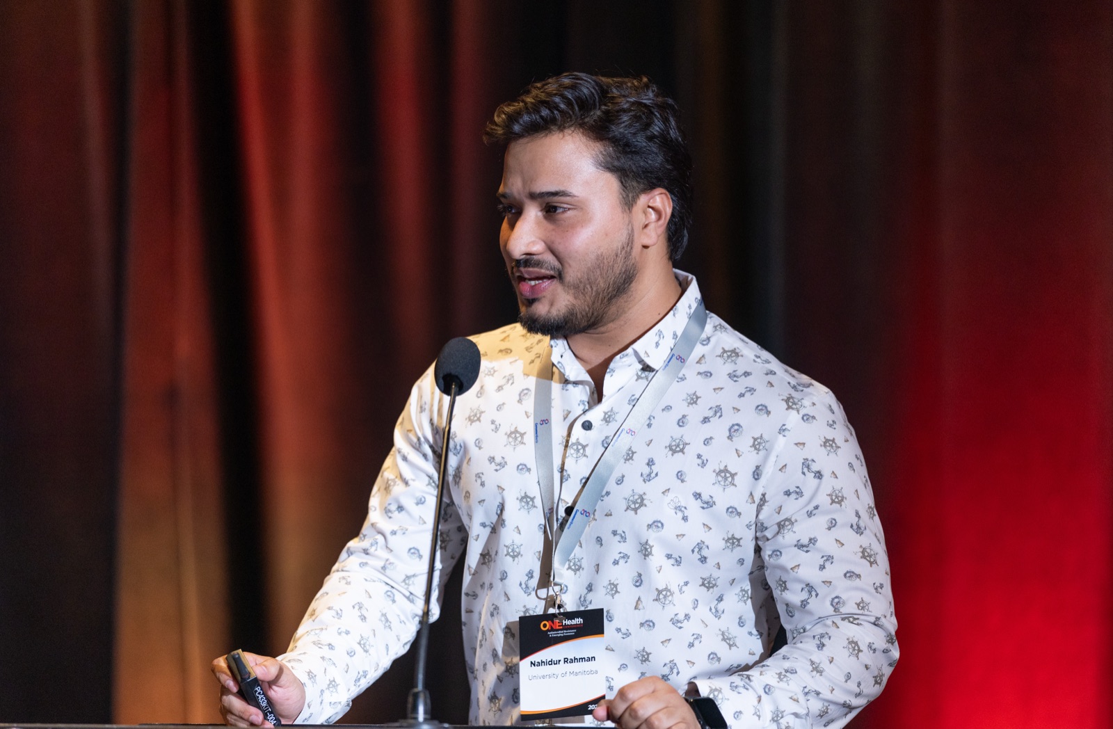 Close-up of Nahidur Rahman speaking at the podium