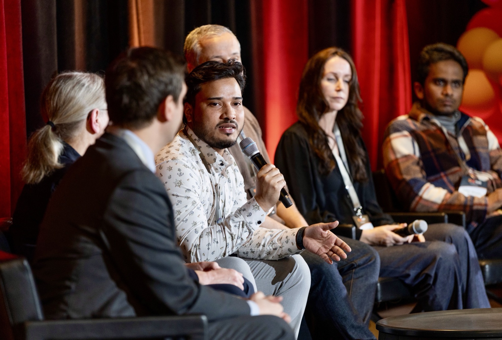 Nahidur Rahman speaking into a microphone alongside fellow panelists